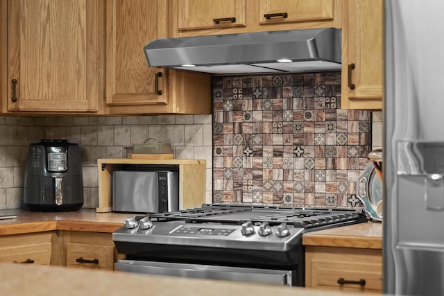 104 Alpena Trl, Houghton Lake, MI 48629 - kitchen featuring range hood, stainless steel appliances, tasteful backsplash, and light countertops