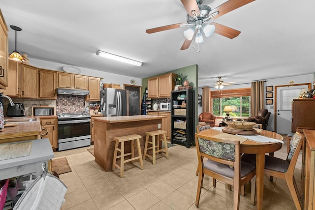 104 Alpena Trl, Houghton Lake, MI 48629 - kitchen with stainless steel appliances, under cabinet range hood, decorative backsplash, a ceiling fan, and light countertops