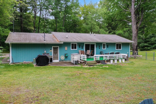 104 Alpena Trl, Houghton Lake, MI 48629 - rear view of house with a wooden deck, view of wooded area, and roof with shingles