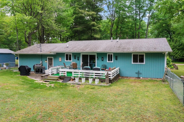104 Alpena Trl, Houghton Lake, MI 48629 - rear view of house with a fenced backyard, a deck, and roof with shingles