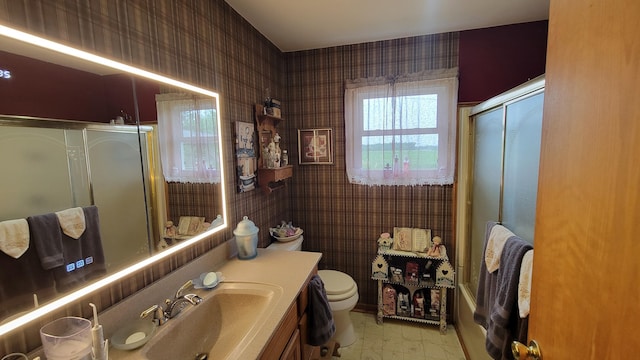 2012 S F-41, Mikado, MI 48745 - full bathroom featuring toilet, vanity, wallpapered walls, and bath / shower combo with glass door