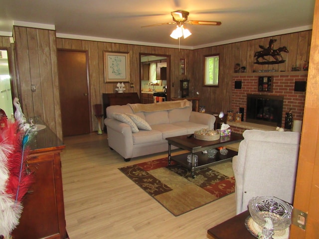 110 Chippewa Trl, Prudenville, MI 48651 - living room featuring wooden walls, a ceiling fan, wood finished floors, a brick fireplace, and ornamental molding
