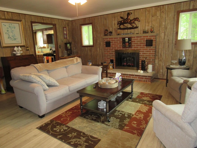 110 Chippewa Trl, Prudenville, MI 48651 - living area with wood walls, light wood finished floors, and a brick fireplace