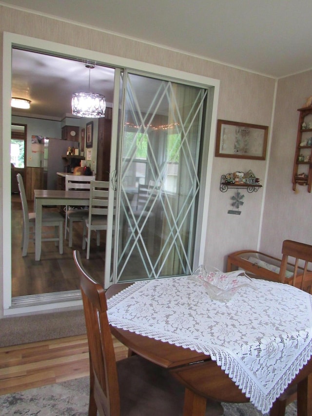 110 Chippewa Trl, Prudenville, MI 48651 - dining area featuring wood finished floors, crown molding, and a chandelier