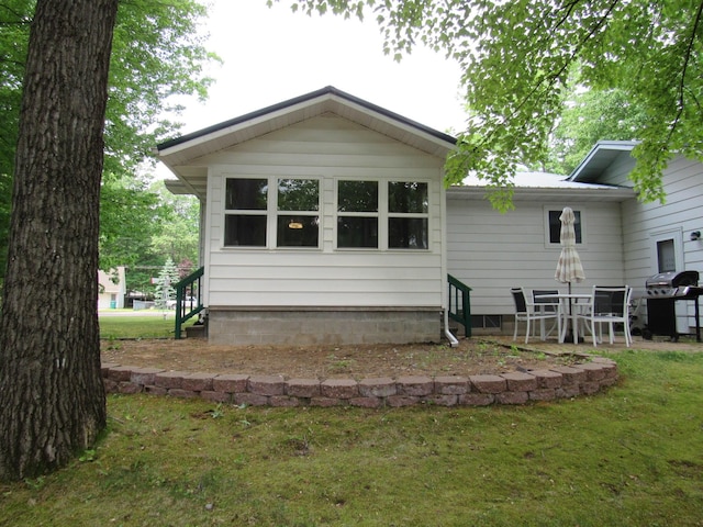 110 Chippewa Trl, Prudenville, MI 48651 - rear view of property featuring a lawn and a patio area