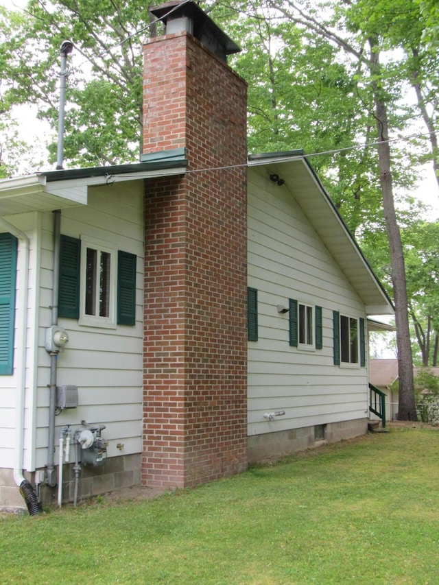 110 Chippewa Trl, Prudenville, MI 48651 - view of side of home featuring a chimney and a lawn