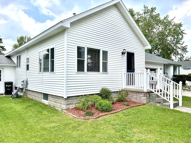 300 E Blair St, Alpena, MI 49707 - view of front of house with a front lawn, roof with shingles, and an attached garage