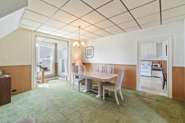757 N Main St, Cheboygan, MI 49721 - carpeted dining space with wainscoting, a chandelier, a drop ceiling, wooden walls, and a baseboard heating unit