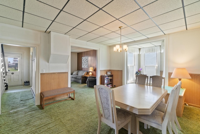 757 N Main St, Cheboygan, MI 49721 - dining room featuring a wainscoted wall, carpet, wooden walls, a chandelier, and a paneled ceiling