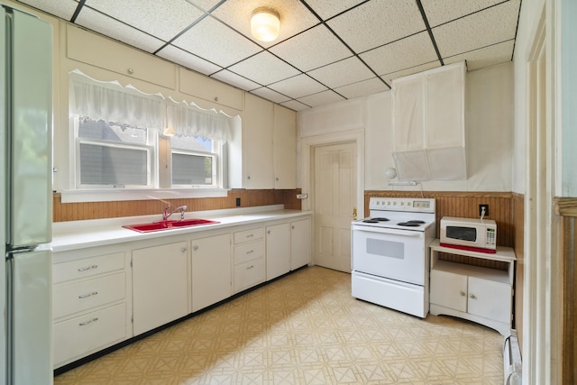 757 N Main St, Cheboygan, MI 49721 - kitchen with white appliances, light countertops, a paneled ceiling, and light floors