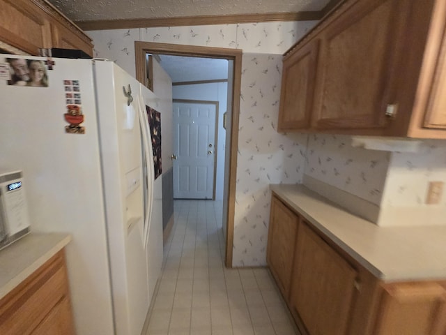 6709C E Houghton Lake Dr, Houghton Lake, MI 48629 - kitchen with white fridge with ice dispenser, wallpapered walls, brown cabinets, light countertops, and crown molding