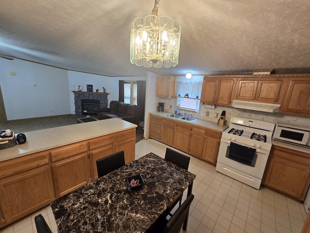6709C E Houghton Lake Dr, Houghton Lake, MI 48629 - kitchen featuring white appliances, extractor fan, a fireplace, a chandelier, and a textured ceiling