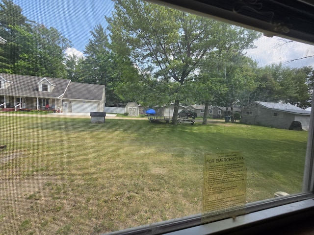 6709C E Houghton Lake Dr, Houghton Lake, MI 48629 - view of green lawn featuring view of wooded area