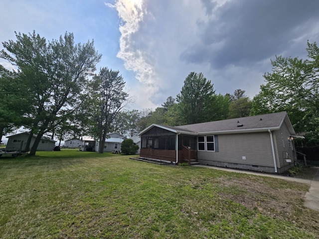 6709C E Houghton Lake Dr, Houghton Lake, MI 48629 - rear view of property featuring a sunroom, crawl space, and a lawn