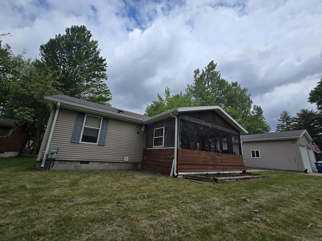6709C E Houghton Lake Dr, Houghton Lake, MI 48629 - back of property featuring a sunroom and a lawn