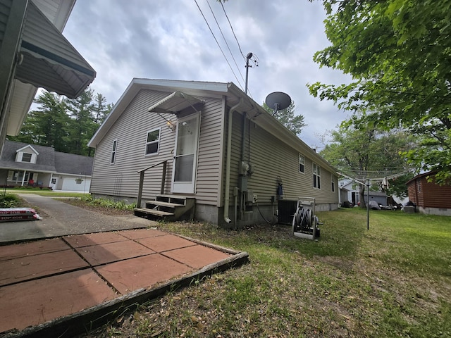 6709C E Houghton Lake Dr, Houghton Lake, MI 48629 - view of side of home with entry steps and a yard
