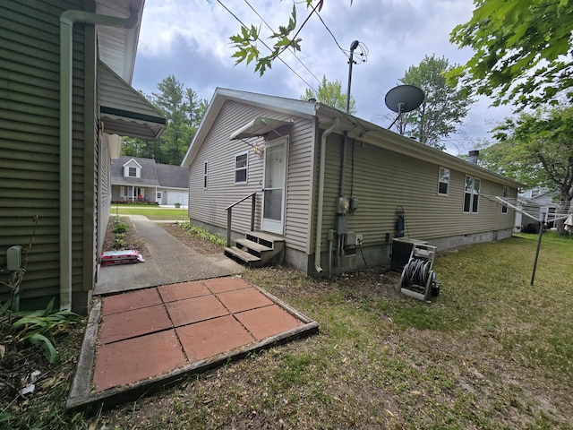6709C E Houghton Lake Dr, Houghton Lake, MI 48629 - view of side of home featuring entry steps and a yard