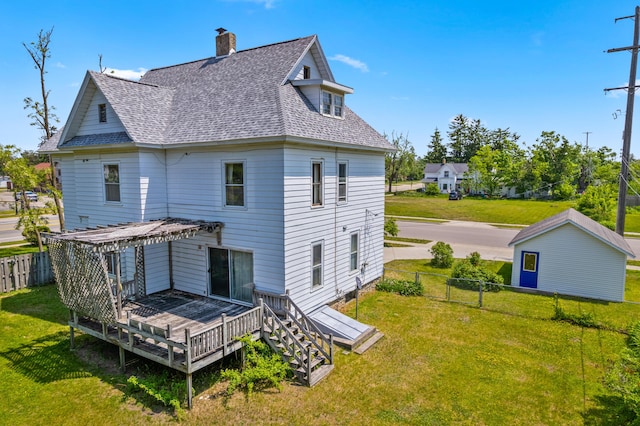 220 E Main St, Gaylord, MI 49735 - back of property with a wooden deck, roof with shingles, and a chimney