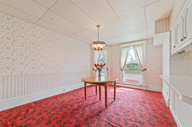 220 E Main St, Gaylord, MI 49735 - dining space with wallpapered walls, a wainscoted wall, carpet flooring, a chandelier, and a drop ceiling