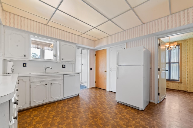 220 E Main St, Gaylord, MI 49735 - kitchen with white appliances, wallpapered walls, a chandelier, white cabinetry, and light countertops