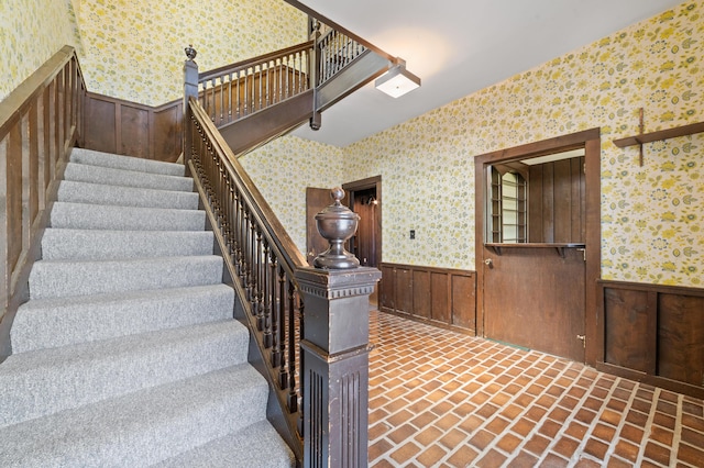 220 E Main St, Gaylord, MI 49735 - stairway with wallpapered walls, a wainscoted wall, brick floors, and wooden walls