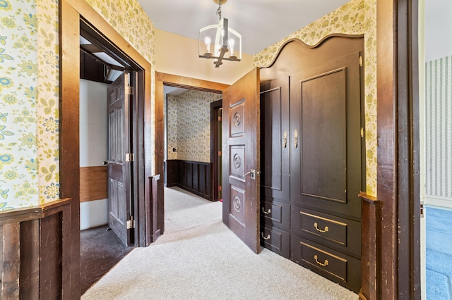 220 E Main St, Gaylord, MI 49735 - hall featuring wallpapered walls, wainscoting, a chandelier, and carpet flooring