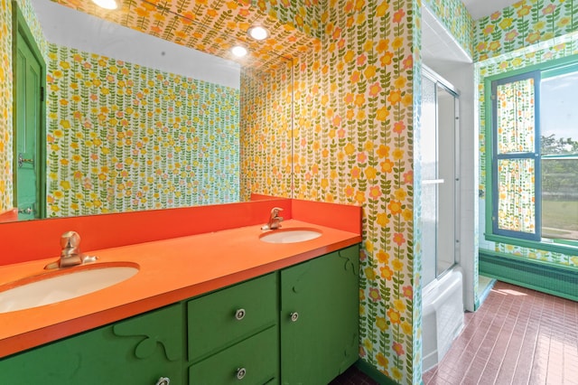 220 E Main St, Gaylord, MI 49735 - bathroom with wallpapered walls, double vanity, radiator heating unit, tile patterned flooring, and shower / bath combination with glass door