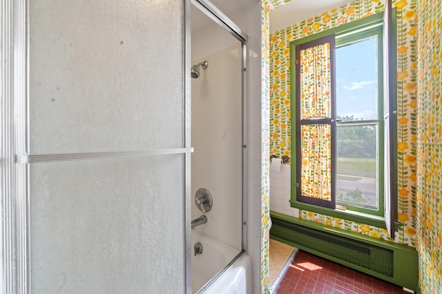220 E Main St, Gaylord, MI 49735 - full bath with bath / shower combo with glass door, radiator heating unit, and tile patterned floors