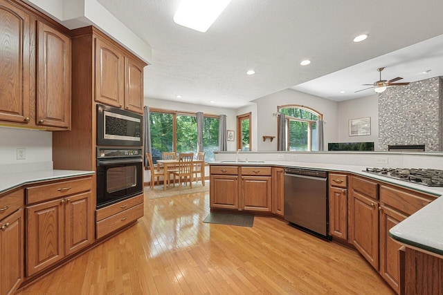 142 Frisco Dr, Houghton Lake, MI 48629 - kitchen featuring appliances with stainless steel finishes, brown cabinetry, healthy amount of natural light, and recessed lighting