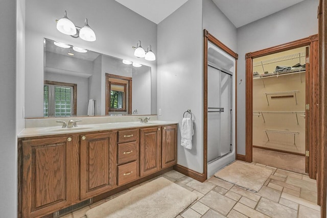 142 Frisco Dr, Houghton Lake, MI 48629 - bathroom with a stall shower, double vanity, a walk in closet, and stone finish flooring