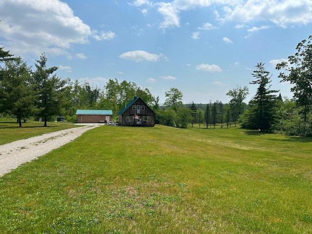 2585 M-33, Comins, MI 48619 - view of green lawn with an outdoor structure, driveway, and a detached garage