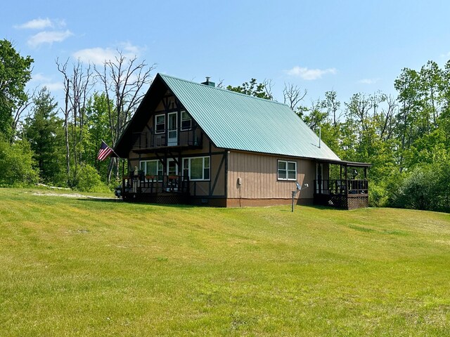2585 M-33, Comins, MI 48619 - view of side of property with a yard, a wooden deck, and a metal roof