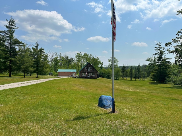 2585 M-33, Comins, MI 48619 - view of green lawn with driveway and a garage