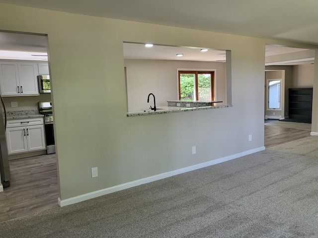 1251 Kingston Ave, Flint, MI 48507 - kitchen featuring appliances with stainless steel finishes, white cabinets, carpet floors, and light stone countertops