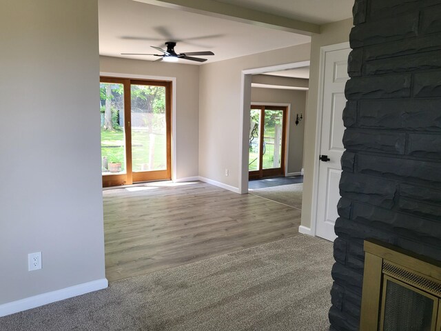 1251 Kingston Ave, Flint, MI 48507 - empty room with healthy amount of natural light, a ceiling fan, a fireplace, and carpet