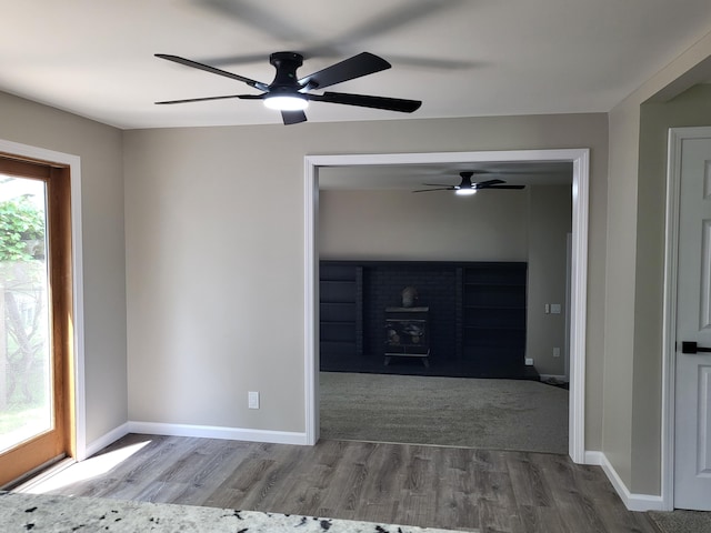 1251 Kingston Ave, Flint, MI 48507 - spare room with ceiling fan, wood finished floors, and a wood stove