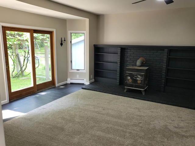 1251 Kingston Ave, Flint, MI 48507 - unfurnished living room with a wood stove, baseboard heating, carpet floors, tile patterned flooring, and ceiling fan
