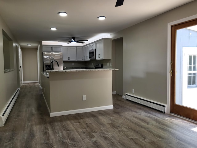 1251 Kingston Ave, Flint, MI 48507 - kitchen featuring appliances with stainless steel finishes, a baseboard radiator, a ceiling fan, dark wood-type flooring, and recessed lighting