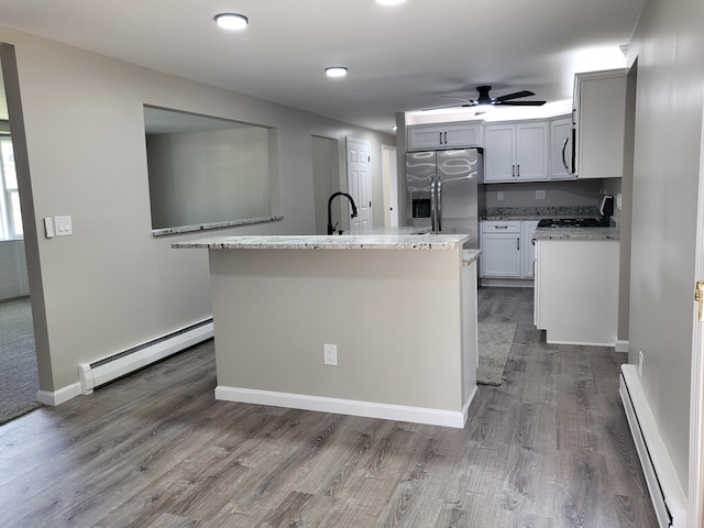 1251 Kingston Ave, Flint, MI 48507 - kitchen with a baseboard radiator, stainless steel appliances, a baseboard heating unit, a ceiling fan, and dark wood-style flooring