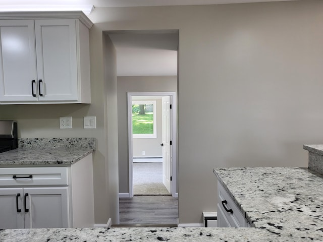 1251 Kingston Ave, Flint, MI 48507 - kitchen featuring wood finished floors, light stone countertops, and a baseboard radiator