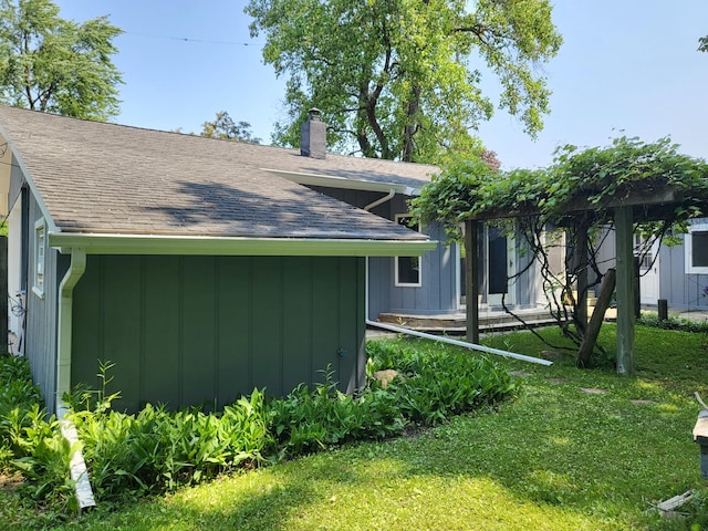 1251 Kingston Ave, Flint, MI 48507 - view of home's exterior featuring roof with shingles, a chimney, a lawn, and board and batten siding
