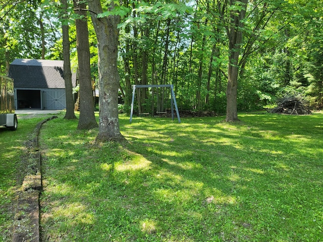 1251 Kingston Ave, Flint, MI 48507 - view of grassy yard with an outbuilding, a garage, and driveway