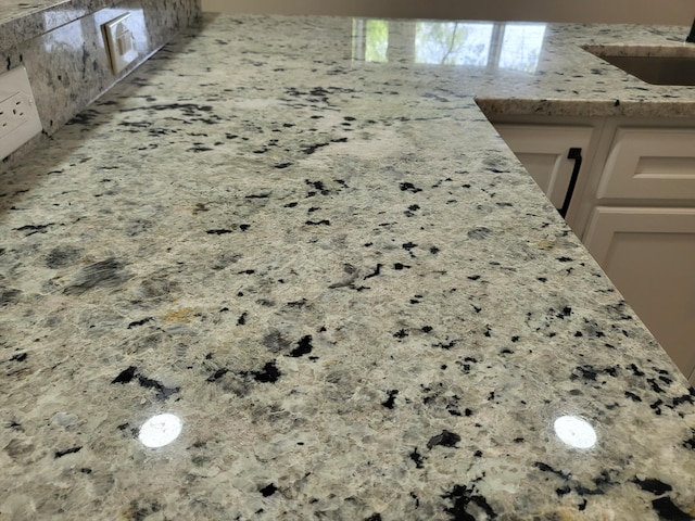 1251 Kingston Ave, Flint, MI 48507 - kitchen view of light stone countertops, decorative backsplash, and white cabinetry