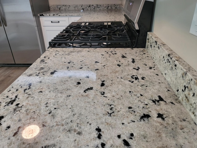 1251 Kingston Ave, Flint, MI 48507 - kitchen view of freestanding refrigerator, range, white cabinets, wood finished floors, and light stone counters