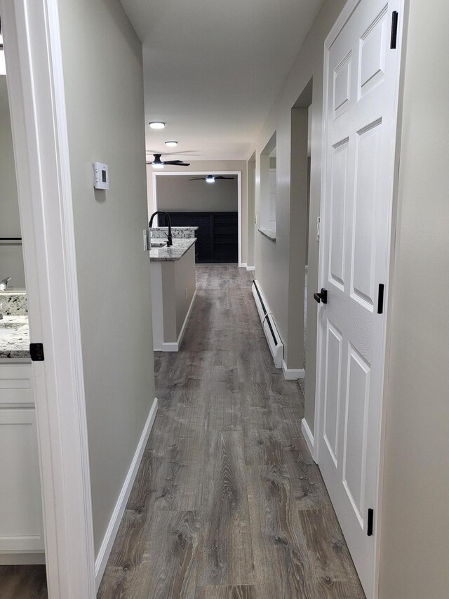 1251 Kingston Ave, Flint, MI 48507 - hall featuring a baseboard heating unit and dark wood-style floors