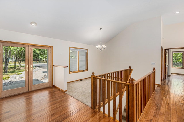 6296 Wolverine Trl, Gaylord, MI 49735 - corridor featuring vaulted ceiling, an upstairs landing, a chandelier, hardwood / wood-style flooring, and french doors