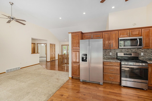 6296 Wolverine Trl, Gaylord, MI 49735 - kitchen featuring appliances with stainless steel finishes, a ceiling fan, tasteful backsplash, light wood finished floors, and brown cabinetry
