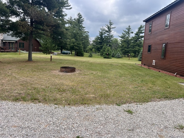 3009 NE Trl, Grayling, MI 49738 - view of green lawn featuring an outdoor fire pit