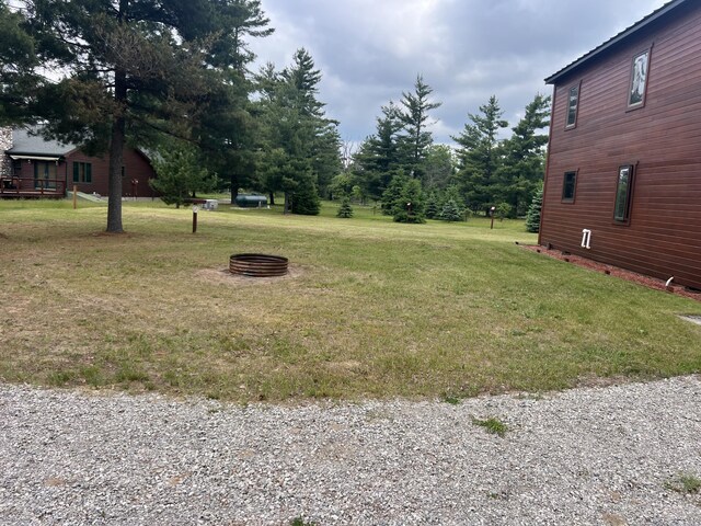 3009 NE Trl, Grayling, MI 49738 - view of green lawn featuring an outdoor fire pit
