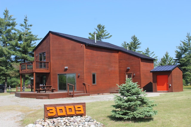 3009 NE Trl, Grayling, MI 49738 - rear view of house with a storage shed, a yard, a deck, a metal roof, and a standing seam roof